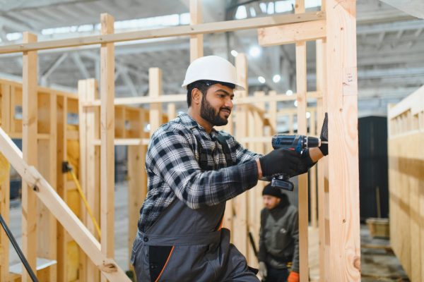 Construction of modular houses. Indian construction worker or engineer at construction site.