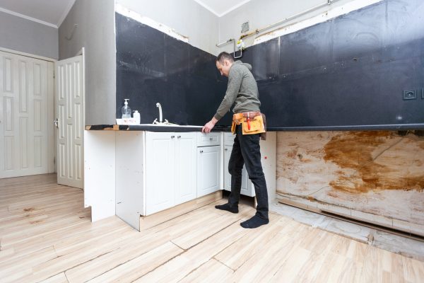 Older man disassembling apartment kitchen out of service. High quality photo